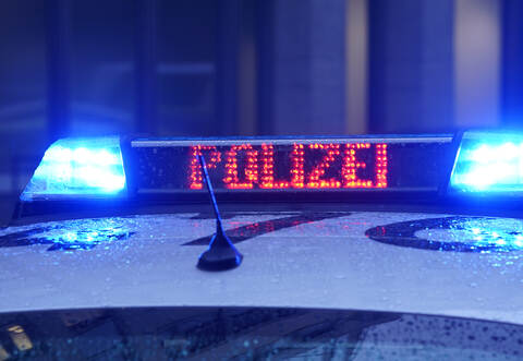 Ein Polizeiauto steht vor einem Gebäude (Symbolbild)