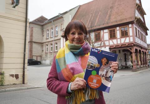 Anne Baumann mit dem Kursprogramm der Volkshochschule.