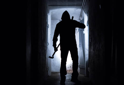 Ein Einbrecher in einem Keller