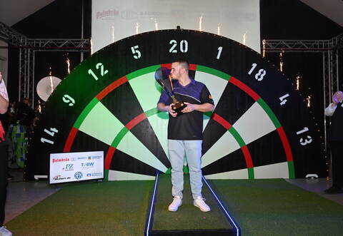 Ein Schmatzer für den Pokal: Darts-Turnier-Sieger Chris "The Wiz" Wörner vom FC Kieselbronn.
