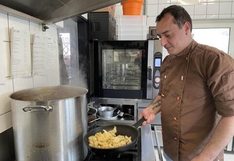 Enrico Handajani bereitet in seiner Küche neben gutbürgerlicher Küche auch vegane und glutenfreie Gerichte zu. Hier schwenkt er gerade Spätzle in der Pfanne.