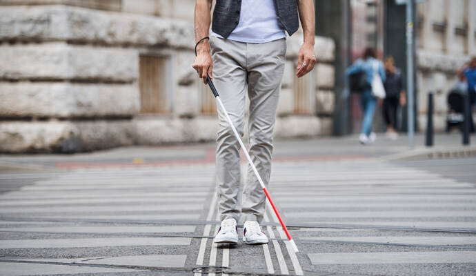 Rund um den Protesttag finden in ganz Deutschland rund 600 Aktionen statt. Midsection of young blind man with white cane walking across the street in city.