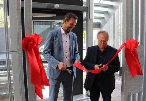 Landrat Bastian Rosenau und Bürgermeister Werner Henle greifen zur Schere, um den Weg für neue Klassenzimmer frei zu machen.