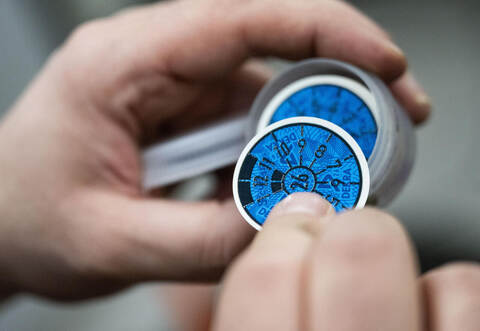 Prüfplakette in Blau bei einer Hauptuntersuchung