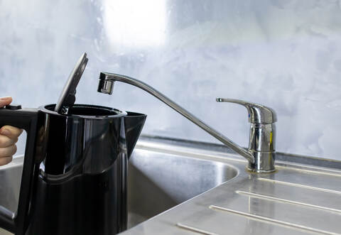 Electric kettle filling with tap water from kitchen sink, Daily water boiling preparation process 