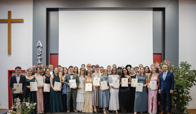 Bestandenes Abitur an der Johann-Christoph-Blumhardt-Schule in Lomersheim: die Abiturientinnen und Abiturienten halten ihr Zeugnis in der Hand.