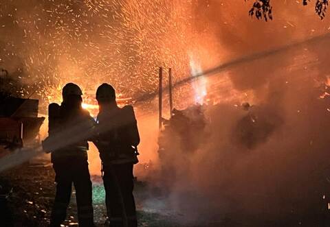 Fireman extinguish fire with the hose. Burning house fire drill