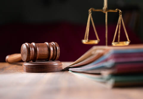 focus on hammer, group of files on judge table covered with dust - concept of pending old cases or work at judicial court