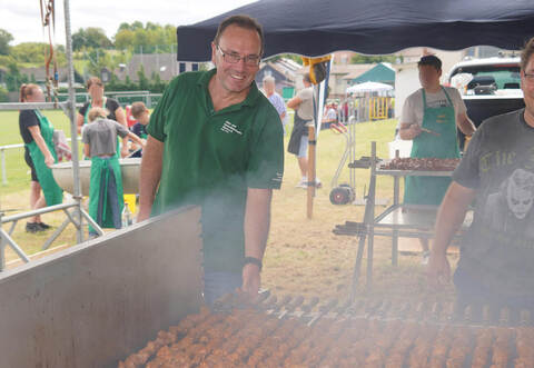 Oliver Rösch (rechts) kümmert sich mit zahlreichen Kollegen um den Spießbraten, der über glühenden Kohlen gart. Ein Engagement, für das ihnen Vorstandsmitglied Uwe Penzinger äußerst dankbar ist.