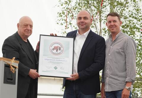 Hubert Flaig (von links) überreicht eine Urkunde des Bundesverbands historischer Landtechnik an den Vorsitzenden Daniel Ahr, der sich mit Bürgermeister Helge Viehweg darüber freut.