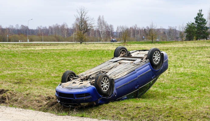 Car accident scene, a passenger car left the road and overturned upside, car rollover