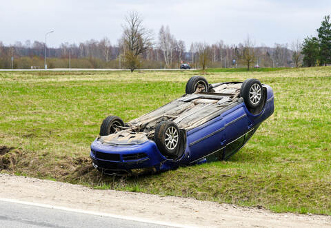 Car accident scene, a passenger car left the road and overturned upside, car rollover