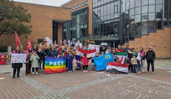 Ein farbenfrohes Bild der internationalen Gemeinschaft: Auf dem Kelterplatz versammeln sich rund 40 Menschen aus verschiedenen Ländern und präsentieren ihre Flaggen.