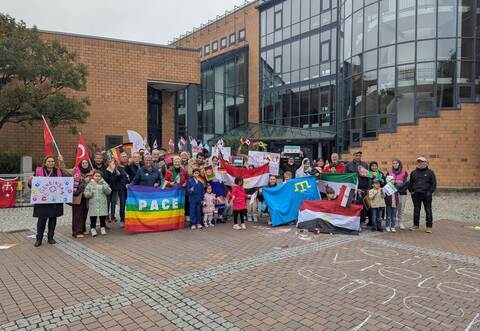 Ein farbenfrohes Bild der internationalen Gemeinschaft: Auf dem Kelterplatz versammeln sich rund 40 Menschen aus verschiedenen Ländern und präsentieren ihre Flaggen.