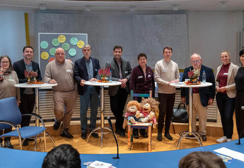 Mit dem Stuhl und den Handpuppen „Ilselotte“ und „Max“ in der Mitte symbolisch Platz für Kinderrechte schaffen möchten (von links): Doris Möller-Espe vom Kinderschutzbund Pforzheim-Enzkreis, Enzkreis Jugendamtsleiter Christopher-Tom Reimann, Rolf Lauterbach (AfD), Hartmut Lutz (BfB), Steffen Bochinger (FWV), Sabrina Bogner-Rudolf (Grüne), Helge Viehweg (SPD), Günter Bächle (CDU), Remchingens Bürgermeisterin Julia Wieland und Alice Zahorneanu vom Jugendamt Enzkreis. Röhr