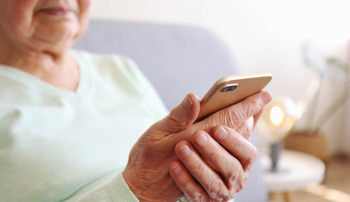 Weil sie dachte, ihrer vermeintlichen Tochter helfen zu können, hat eine ältere Frau Betrügern einen Geldbetrag im unteren fünfstelligen Bereich übergeben. Elderly woman holding blank screen cell phone gadget in hands. Old lady with wrinkled skin trying to vigure out touchscreen smar
