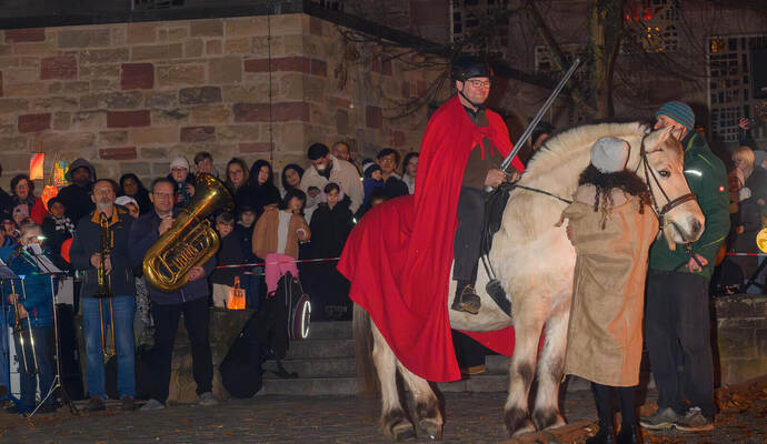 Sankt Martin beziehungsweise sein Darsteller hoch zu Ross. Zahlreiche Gäste finden sich an der Herz-Jesu-Kirche ein.