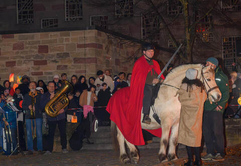 Sankt Martin beziehungsweise sein Darsteller hoch zu Ross. Zahlreiche Gäste finden sich an der Herz-Jesu-Kirche ein.