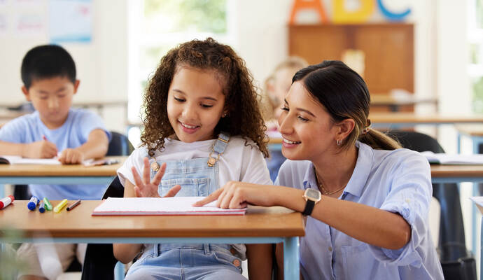 Learning to share is one of the skills we learn at preschool. Shot of a female teacher assisting a preschool learner in her clas