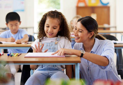 Learning to share is one of the skills we learn at preschool. Shot of a female teacher assisting a preschool learner in her clas