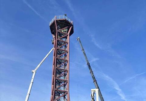 Das Dach der „Hohen Warte“ wurde bereits mit einem Kran angehoben. Jetzt ziehen Gerüstbauer eine Plattform hoch. Diese soll die Aussichtsfläche tragen, sodass schließend die Treppen aus dem Turm geschnitten werden können.