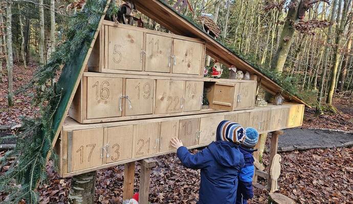 Vor dem großformatigen Adventskalender erleben Kinder den besonderen Zauber des Weihnachtswalds, der mit liebevoll gestalteten Details Jahr für Jahr zahlreiche Besuchende anzieht.