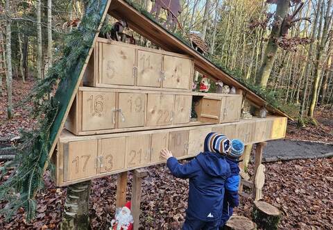 Vor dem großformatigen Adventskalender erleben Kinder den besonderen Zauber des Weihnachtswalds, der mit liebevoll gestalteten Details Jahr für Jahr zahlreiche Besuchende anzieht.