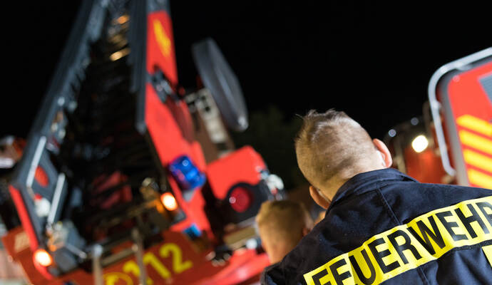 Symbolbild Feuerwehrmann vor Drehleiter