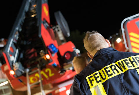 Symbolbild Feuerwehrmann vor Drehleiter