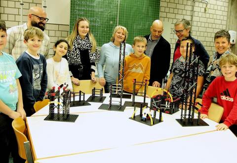 Schüler der ViB in Steinegg stellen ihre ersten Arbeiten mit den Bauteilen des Fischertechnik-Sets vor. Das Foto zeigt Konrektor Markus Pusch (Dritter von links), Klassenlehrerin Sarah Kummer (Fünfte von links), Schulleiterin Helga Schuhmacher (Mitte), Jochen Enke (Wirtschaftsförderung Enzkreis/Achter von links), Stephan Kallauch (Cyber Forum Karlsruhe) und Katrin Zauner (Sparkassen Stiftung Pforzheim-Calw).