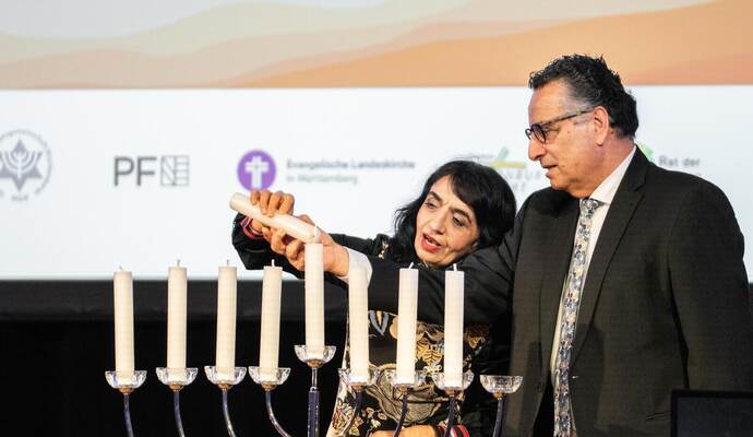 Landtagspräsidentin von Baden-Württemberg Muhterem Aras entzündet den Schamasch (Diener) zusammen mit Rami Suliman, dem Vorstandsvorsitzenden der Jüdischen Gemeinde Pforzheim.