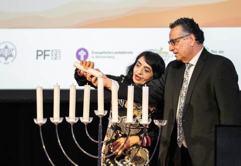 Landtagspräsidentin von Baden-Württemberg Muhterem Aras entzündet den Schamasch (Diener) zusammen mit Rami Suliman, dem Vorstandsvorsitzenden der Jüdischen Gemeinde Pforzheim.