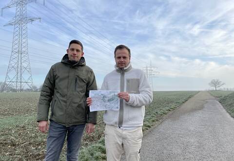 Verunsichert sind Anwohner wie Hendric Reeb (links) und Benjamin Georgopoulos im Gebiet „Kohlplatte“. Die Familienväter zeigen, dass über diesen Weg die Windkraftflächen bei Serres erschlossen werden sollen. Auf der Skizze sind die zu erwartenden Windradpositionen und Abstände zu den Häusern zu sehen.