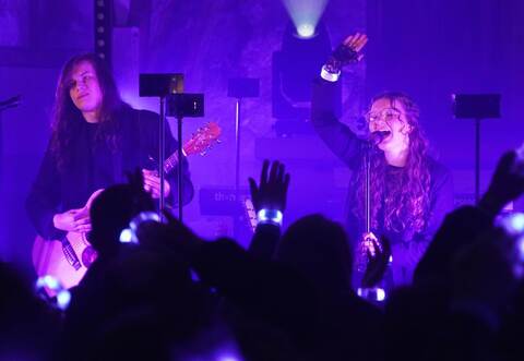 Zwischen Scheinwerfern und leuchtenden LED-Stäben haben sich Leni Hornbach und Lars Rogowski im Altarraum aufgestellt. Immer wieder bitten sie ihre Zuhörer, leuchtende Armbänder in der Luft hin und her zu bewegen.