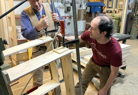Patrick Streit (links) und Tobias Dobler arbeiten am neu angeschafften Leimständer, der für den Betrieb zur Massivholzbearbeitung essenziell ist. rose