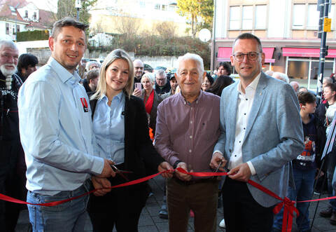 Das rote Band zur Neueröffnung von „Johann’s Imbiss“ durchschneiden in der Mühlacker Bahnhofstraße Ilias Margaritis (von links) und seine Frau Ifigeneia Chaktsi gemeinsam mit dem Imbiss-Gründer, Vater Johann Margaritis, und Oberbürgermeister Stephan Retter. Dahinter warten zahlreiche Kunden auf den Einlass.