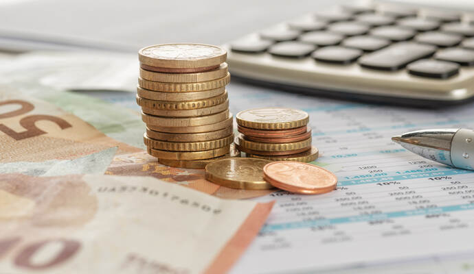 Geld mit Taschenrechner und Kugelschreiber