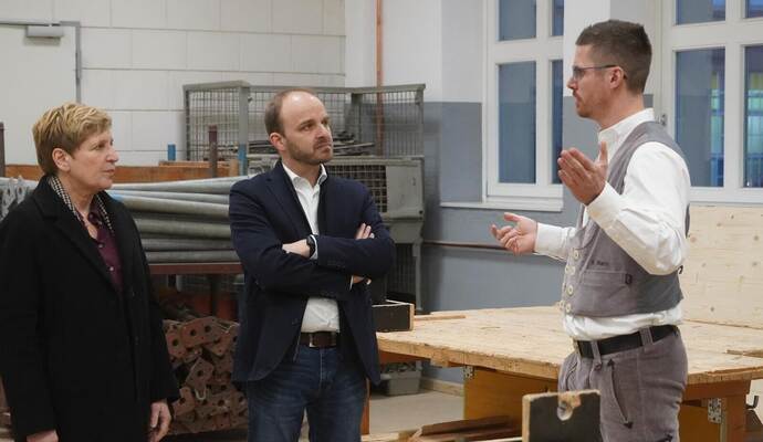 Bauministerin Nicole Razavi und Landtagskandidat Andreas Renner lassen sich von Ausbildungsmeister Fabian Bartz (rechts) die überbetriebliche Ausbildungsstätte zeigen.