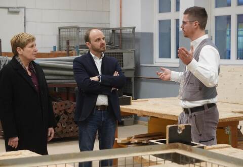 Bauministerin Nicole Razavi und Landtagskandidat Andreas Renner lassen sich von Ausbildungsmeister Fabian Bartz (rechts) die überbetriebliche Ausbildungsstätte zeigen.