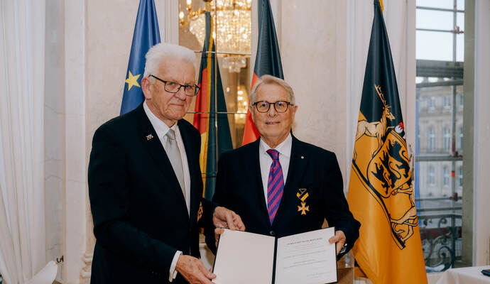 Ministerpräsident Winfried Kretschmann (links) überreicht die Urkunde an  Wolfgang Scheidtweiler.
