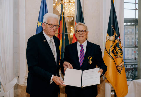 Ministerpräsident Winfried Kretschmann (links) überreicht die Urkunde an  Wolfgang Scheidtweiler.