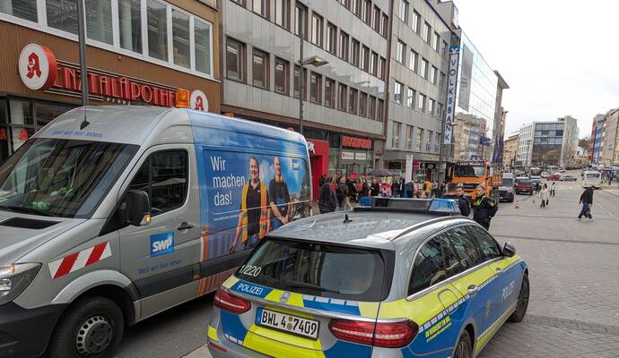 Polizeibeamte regeln den Verkehr vor Ort, während Mitarbeiter der Stadtwerke mit den Reparaturen beginnen.