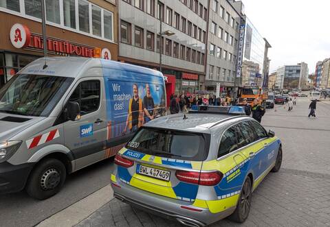 Polizeibeamte regeln den Verkehr vor Ort, während Mitarbeiter der Stadtwerke mit den Reparaturen beginnen.