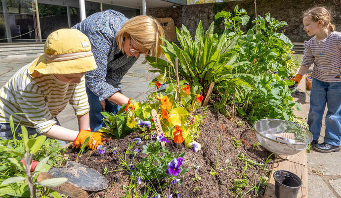 Jona (links) und Alexa (rechts) gärteln unter Anleitung von Museumspädagogin Barbara Freymark. Es sieht nach reicher Ernte aus, und davon können alle Besucher des Schmuckmuseums an diesem Freitag kosten – solange der Vorrat reicht.