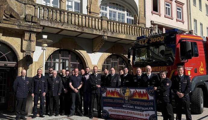 Überraschung für den Feuerwehrkommandanten: Zahlreiche Feuerwehrangehörige haben ihn mit zwei Fahrzeugen und einem Banner vor dem Rathaus empfangen.