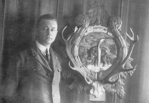 So präsentiert sich die Liederkranz-Vereinsstandarte von Karl Spingler aus dem Jahr 1926 noch heute als Wandschmuck beim Eingang zum Nebenraum der Gaststätte „Alte Linde“. Der Künstler hat sich mit seinem Werk ablichten lassen.