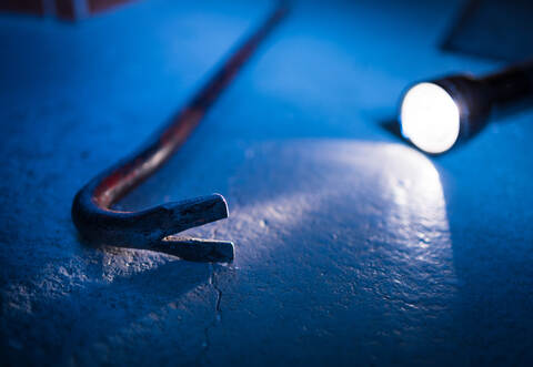 Symbolbild Einbruch, Taschenlampe mit Brechstange