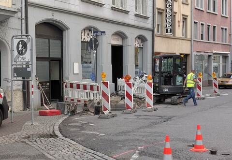 Mit einem kleinen Bagger legt der Mitarbeiter das Rohr in der Westlichen Karl-Friedrich-Straße frei.