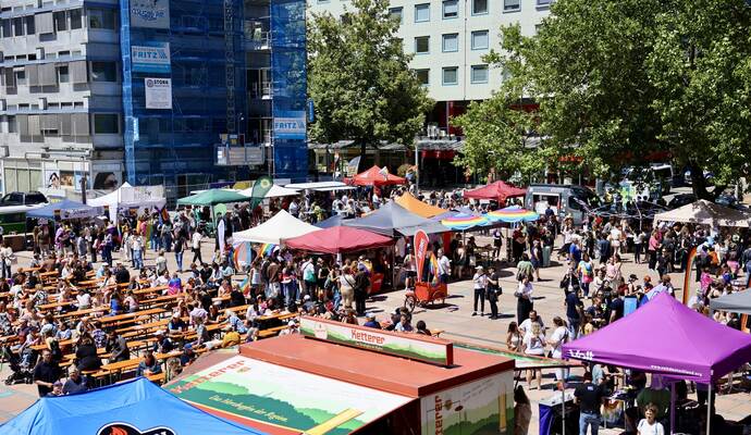 Auf dem Marktplatz genießen die Menschen die Sonne und feiern ausgelassen.