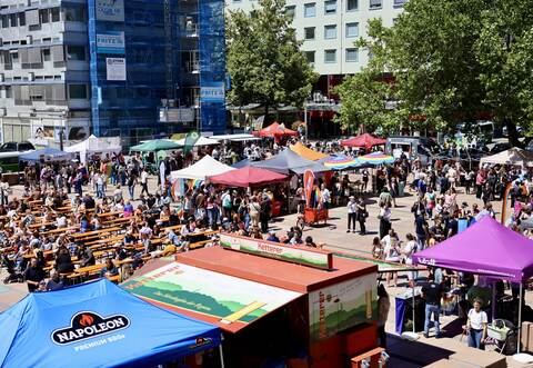 Auf dem Marktplatz genießen die Menschen die Sonne und feiern ausgelassen.